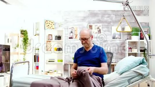 护士帮助一位残疾退休老人从病床上站起来视频