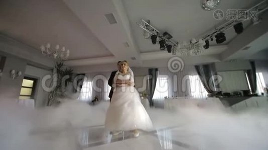 婚礼上的新娘舞会。 用白光突出的浓烟。 新婚夫妇的第一支舞蹈视频