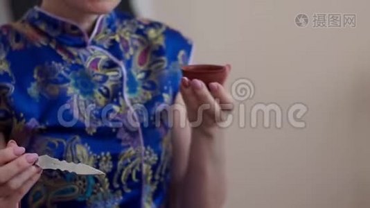 一个长相甜美的白人女孩，捧着一杯香茶，讲述了茶道是如何举行的视频