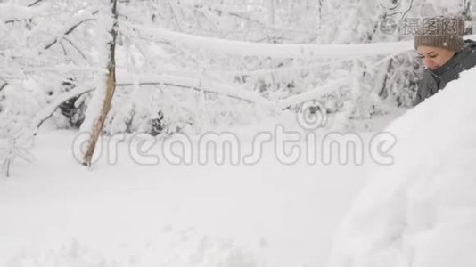 那个女人在冬天白雪覆盖的汽车里打开后备箱。 冬天，一个女人从一辆车上擦雪。视频