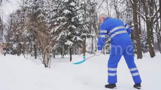 高级清洁工在公园里除雪。视频
