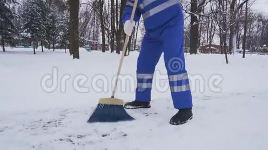 隐名清洁工用扫帚清除积雪。视频