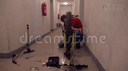 一个人在公寓大楼的地下室修理自行车。视频