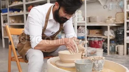 制作米色粘土特写花瓶。 作坊里的雕刻家用粘土做罐子. 扭曲的锅`轮子视频