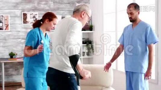 老人拄着拐杖，由年轻的男医生和女医生帮助视频