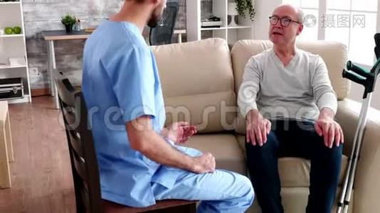 年轻有胡子的医生在和老人说话视频