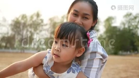快乐的亚洲妈妈和小女儿一起在夏天的公园玩.. 幸福家庭和童年的概念..视频