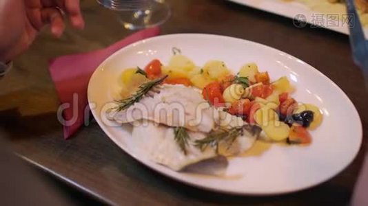 在餐馆里，一个人在桌上端着配菜，吃着头的鱼片视频