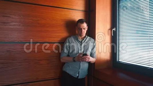 一个男人站在办公室的一个角落打电话给他的搭档。视频