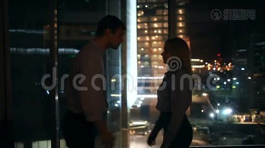 一对年轻夫妇的关系很困难。 在一扇俯瞰夜城的大窗户的背景下视频