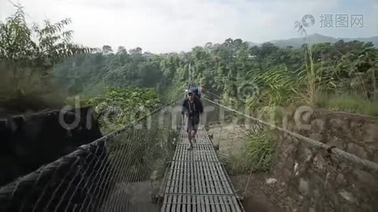 一个背包客在尼泊尔过桥。 森林，探险，高山，森林..视频