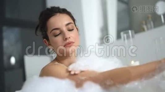 特写放松的感官洗手在浴缸。 可爱的女人在洗澡时放松。视频