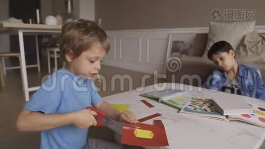 专心致志的5岁男孩用剪刀热情地剪纸。 伸出舌头。 集中5岁男孩剪纸视频