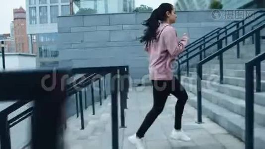 运动员妇女在户外运动中跑上楼梯。 健身女孩在楼上慢跑视频