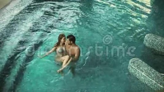 幸福夫妇享受游泳池的最高景观。 欢乐的一对在健康的酒店放松视频