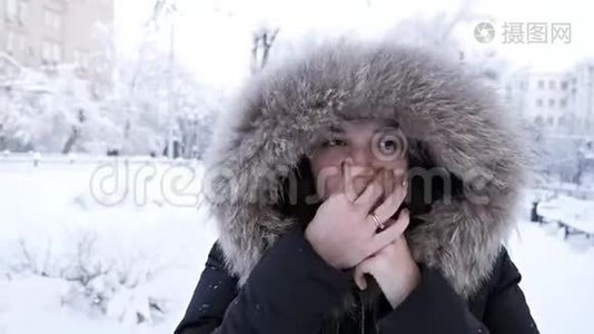 冬天的女孩吹在她的手上，寒冷的天气。 雪。 霜冻，冻僵，少女在冬季公园散步视频