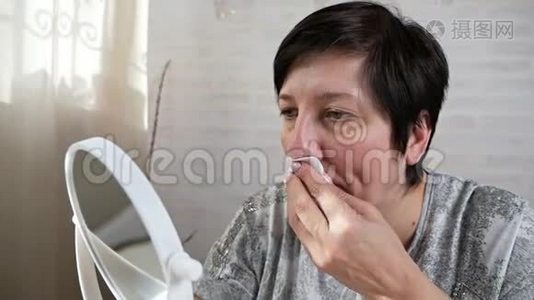 一位老年妇女借助清洁贴纸去除鼻子皮肤上的黑点。 鼻腔清洗条视频