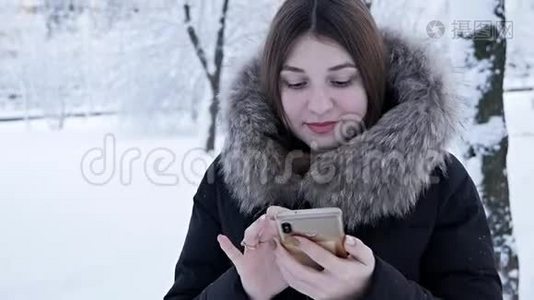 一个女人在寒冷的冬天打电话。 冬天下雪视频