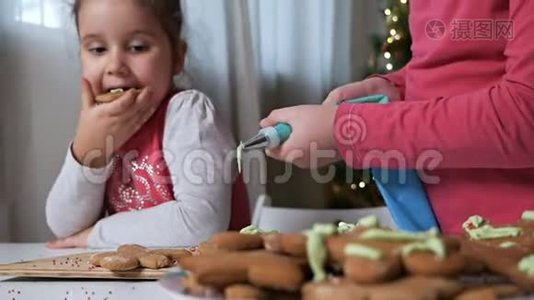 两个可爱的小女孩，女孩们，在美丽的圣诞节的背景下为圣诞节准备姜饼视频