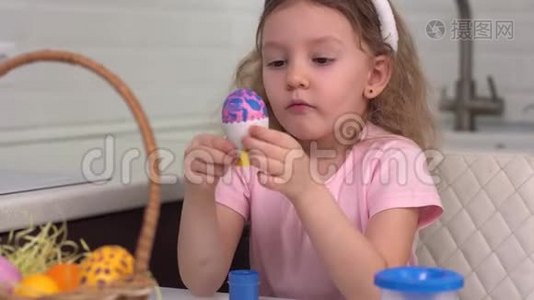 复活节快乐。 小女孩画复活节彩蛋。 为复活节做准备的快乐家庭孩子。 可爱的小女孩视频