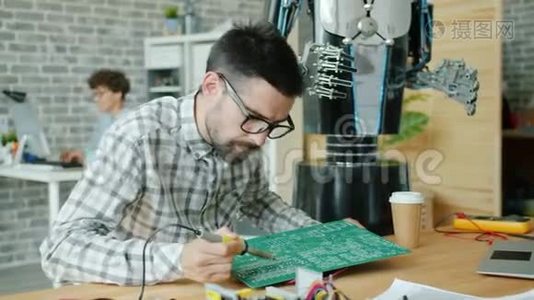 男技师用卖方制造机器人修理微电路板视频