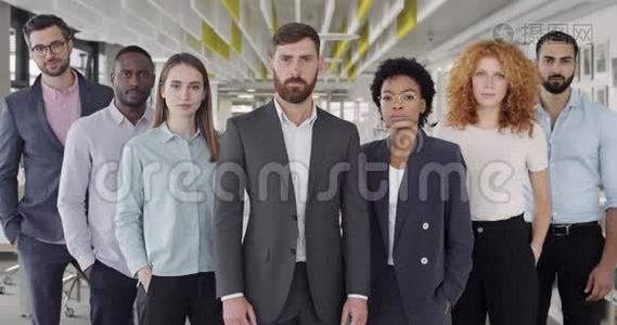站在现代办公室的自信团队的肖像。 成功的男女办公室工作人员寻找镜头视频