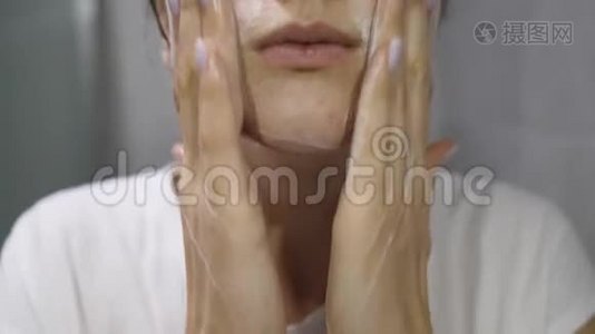 皮肤漂亮的健康女孩用白色泡沫近距离洗脸视频