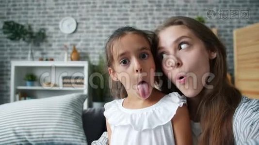 有趣的女人和女孩妈妈和女儿做滑稽的脸自拍视频