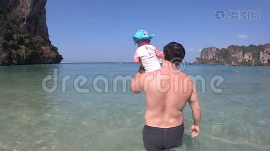一位父亲肩上扛着一个小女儿，走进大海.. 宝宝第一次看到大海..视频