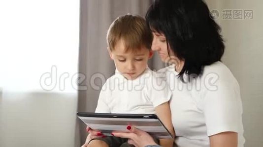 母亲和她的小儿子用平板电脑看电影，玩游戏，或者打电话。视频