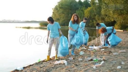 一群年轻人从垃圾中收集河岸清洁自然的废物视频