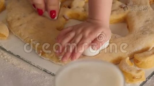妈妈和女儿的特写从厨房的面团里切出饼干的形状。视频