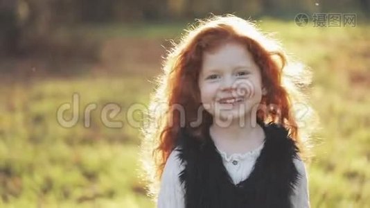 可爱的红头发小女孩在秋天公园散步的肖像。 慢动作。 秋天公园。 小女孩微笑着视频