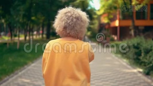 后景金发女人在公园散步视频