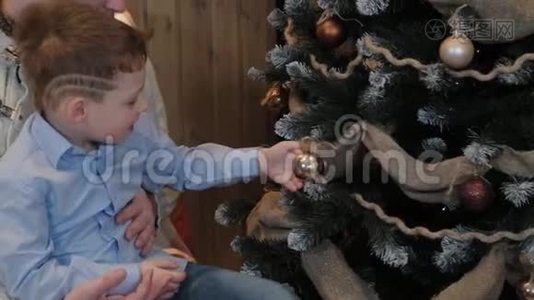 快乐的爸爸和小儿子在现代的室内装饰圣诞树。视频