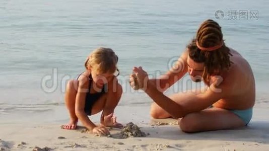 父亲和女儿在海滨建了一座沙堡视频