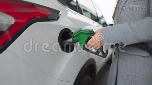 在加油站的一个特写镜头里，女人往她的车里灌汽油视频