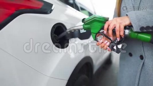 在加油站的一个特写镜头里，女人往她的车里灌汽油。 慢动作视频