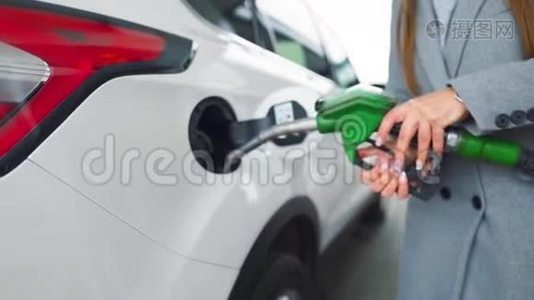 在加油站的一个特写镜头里，女人往她的车里灌汽油。 慢动作视频
