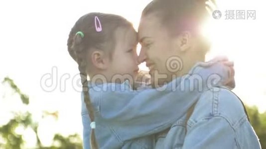 幸福的家庭，母亲和孩子在公园的户外玩得开心。 可爱的女孩在玩，拥抱和亲吻她的母亲。视频