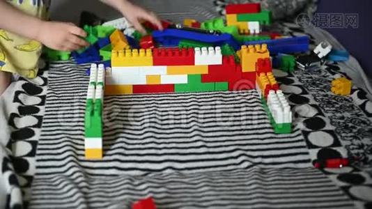 快乐的孩子在条纹沙发上的彩色积木里玩耍视频