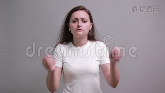 一个穿着白色衬衫的疲惫女人，双手托着头，头疼视频