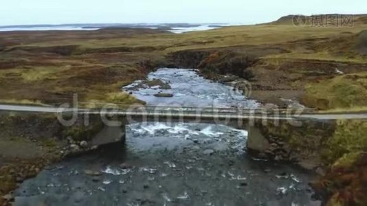 鸟瞰：经过山上的一座桥，顺着河路，石桥..视频