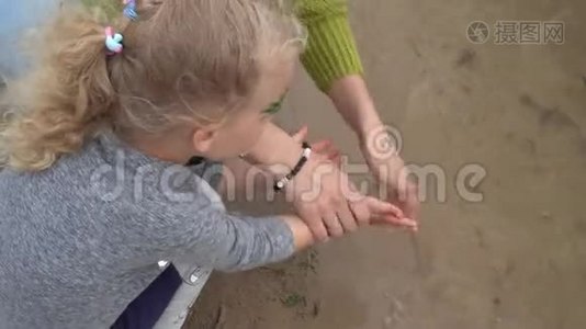 母亲在湖水中给女儿洗手。 万向节运动视频