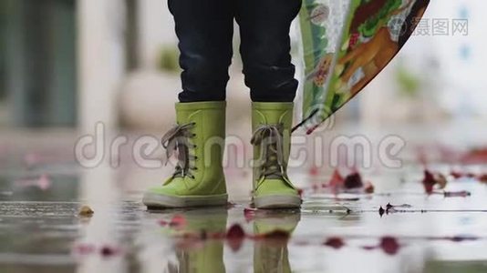 雨中穿着橡胶靴的小男孩站在水坑里视频