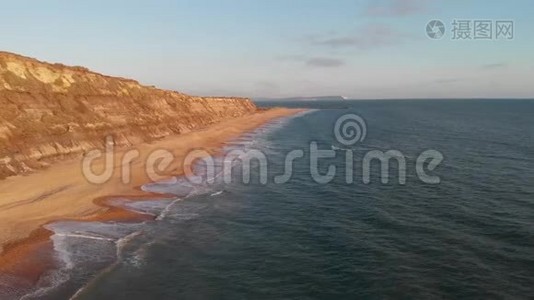 一段横斯伯里头悬崖的空中向前镜头，美丽的沙滩和水晶般的蓝色的水在雄伟的蓝色天空下视频