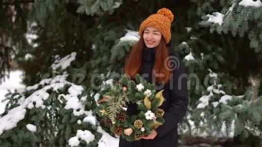 白雪皑皑的白天，美丽的白种人女孩和户外圣诞花环视频