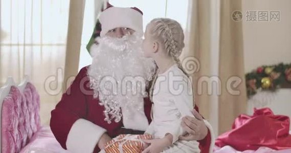 穿圣诞老人服装的白种人成年男子假胡子抱着可爱的女孩跪在地上的肖像，小孩告诉他视频