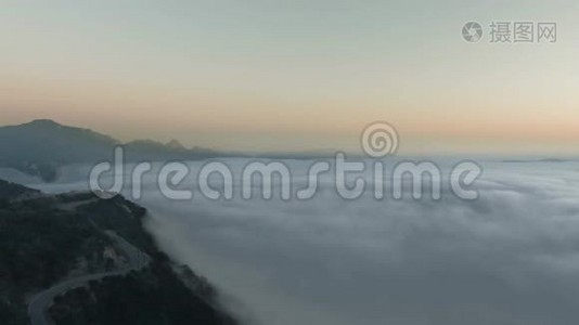 空中景色飞过一座郁郁葱葱的青山，云下有一条弯曲的路视频