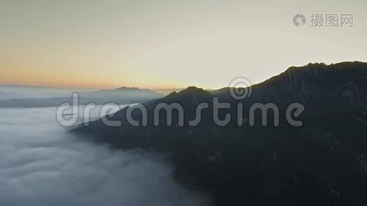 无人机照相机飞过美丽的云层，拍摄隐藏在山后的太阳视频